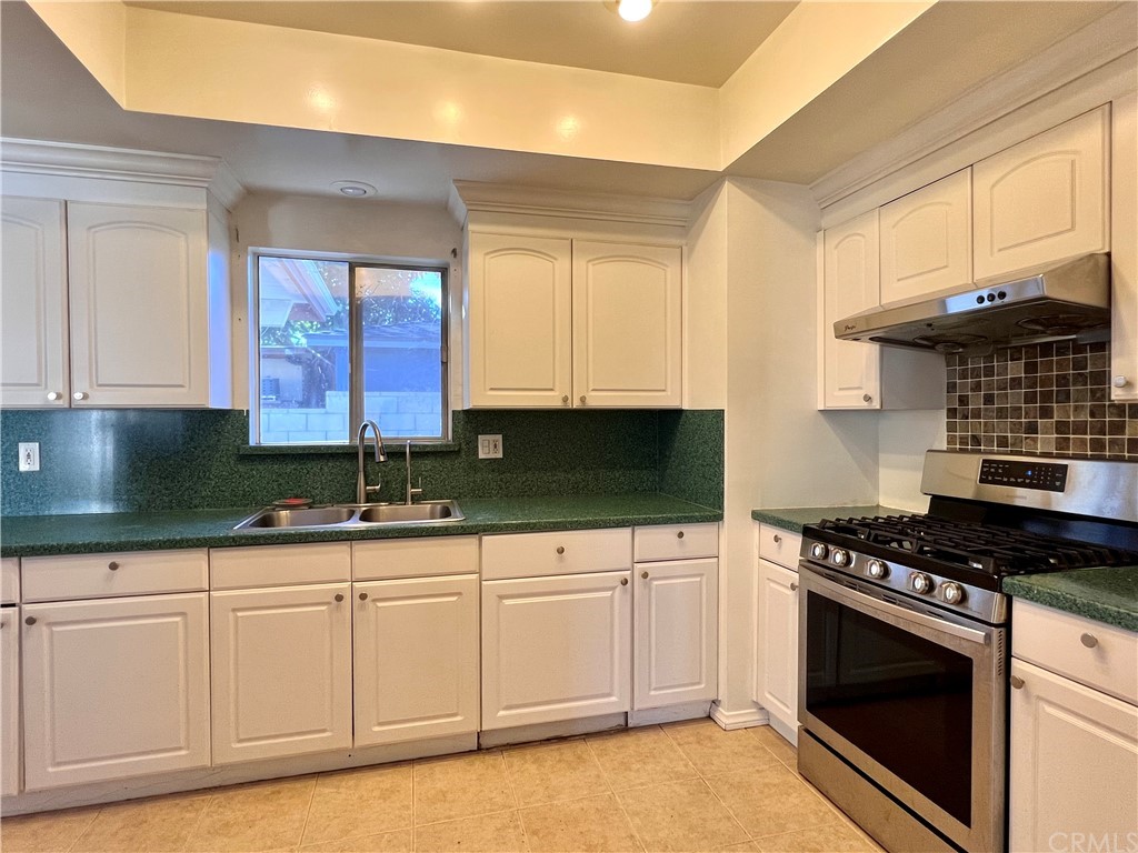 8716 Duarte Road San Gabriel, CA 91775 - Photo 9 of 21 a kitchen with granite countertop a sink a stove and cabinets