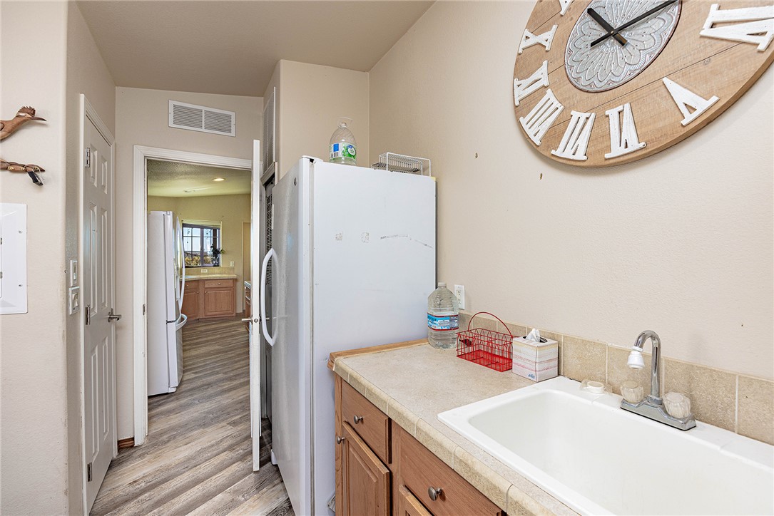 4206 Cordes Road Golden Valley, AZ 86413 - Photo 12 of 60 The property features a utility area with a sink, countertop, and lower cabinetry, alongside a full-size refrigerator