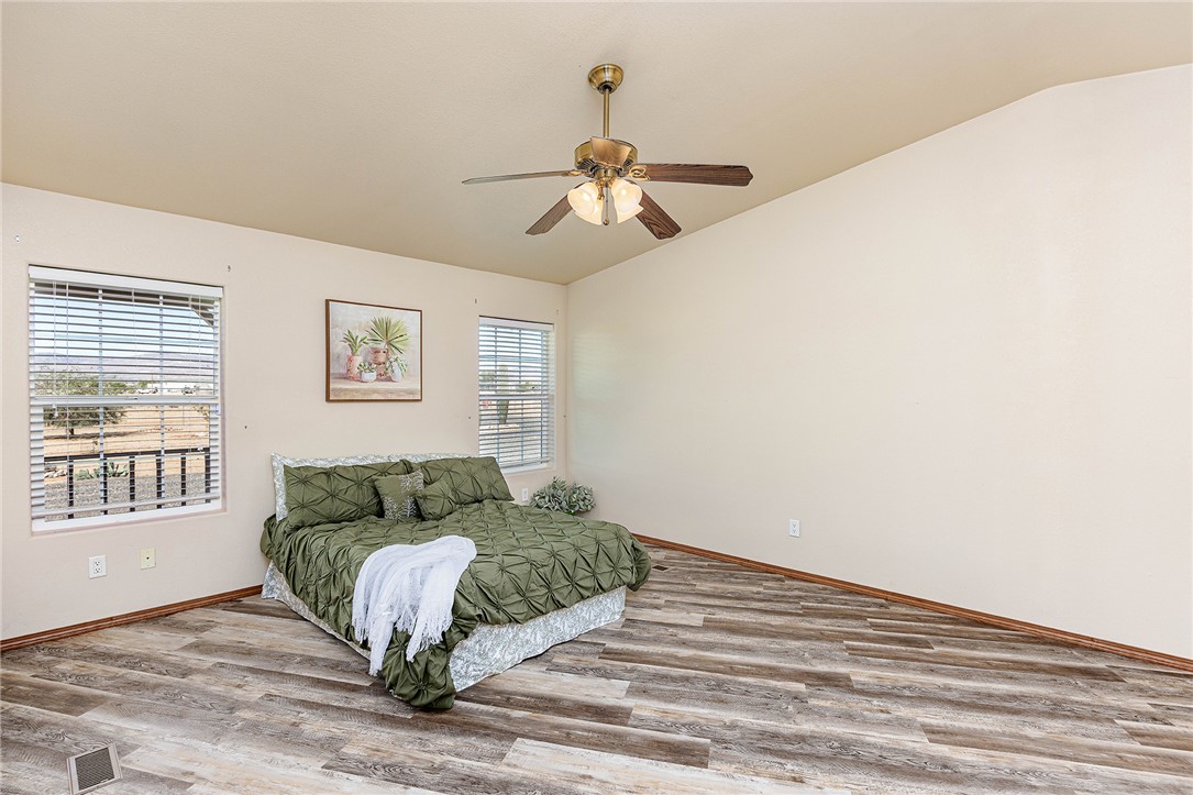 4206 Cordes Road Golden Valley, AZ 86413 - Photo 14 of 60 This room features vaulted ceilings, wood-look flooring, and a ceiling fan with light fixture