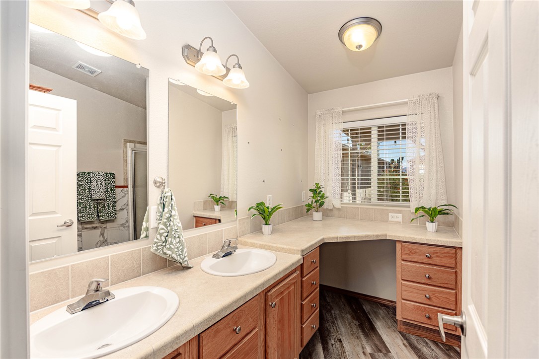 4206 Cordes Road Golden Valley, AZ 86413 - Photo 17 of 60 Spacious bathroom featuring dual sinks, ample counter space with a dedicated vanity area, and a window providing natural light