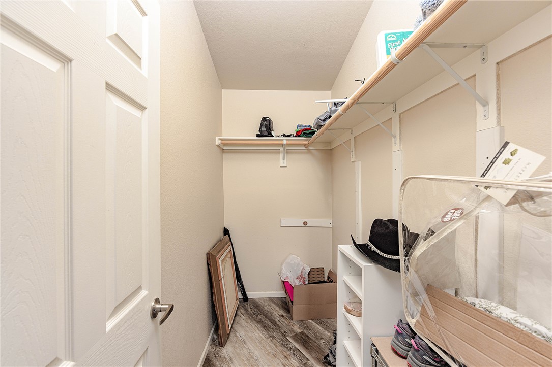 4206 Cordes Road Golden Valley, AZ 86413 - Photo 19 of 60 This walk-in closet features light-colored walls, wood-look flooring, and white shelving units