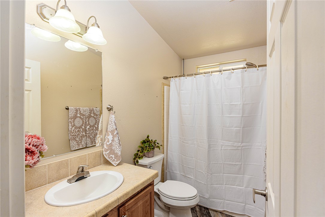 4206 Cordes Road Golden Valley, AZ 86413 - Photo 23 of 60 Bathroom featuring a vanity with an integrated sink, a mirror with overhead lighting, and a shower with a shower curtain