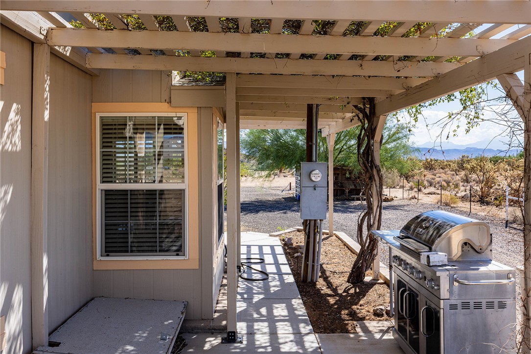 4206 Cordes Road Golden Valley, AZ 86413 - Photo 26 of 60 The property features a pergola-covered patio area with views of the surrounding desert landscape and distant mountains