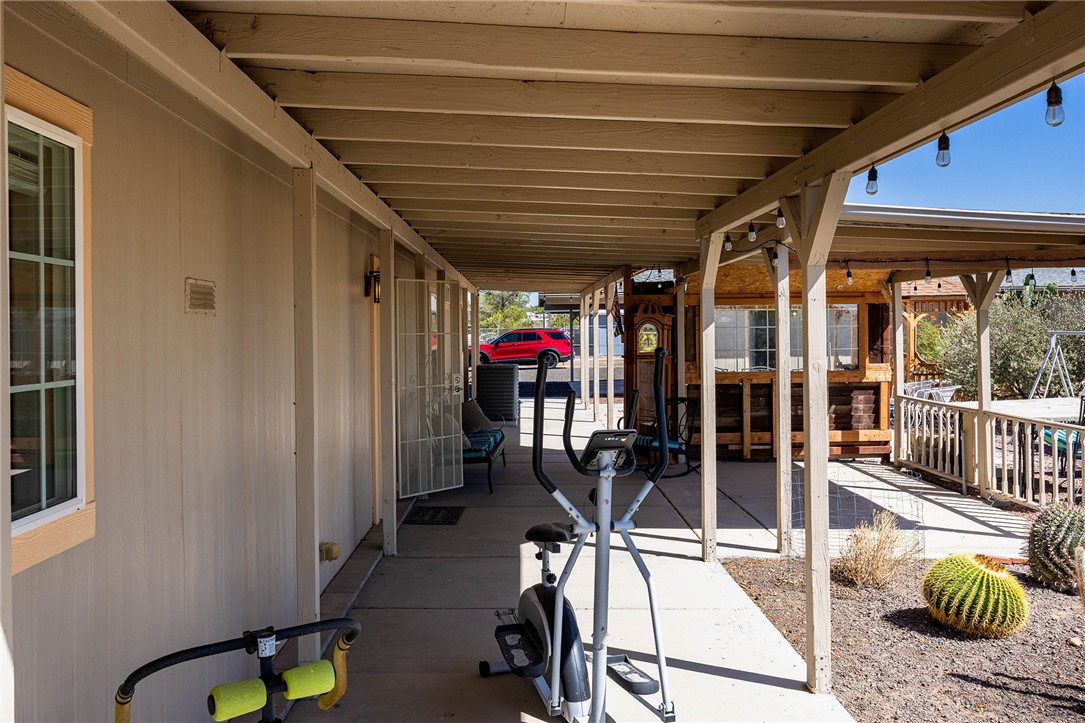 4206 Cordes Road Golden Valley, AZ 86413 - Photo 27 of 60 The property features an extensive covered patio area with exposed beams and string lights, providing a shaded outdoor living space