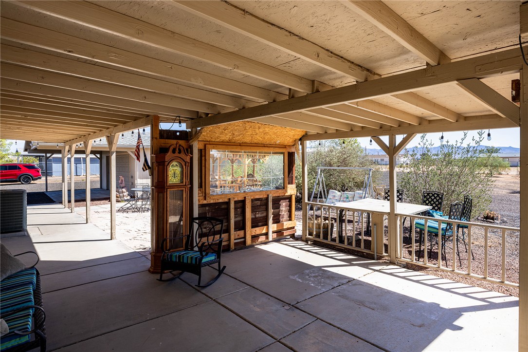 4206 Cordes Road Golden Valley, AZ 86413 - Photo 30 of 60 Covered patio area featuring a concrete floor, a wooden balustrade, and string lights