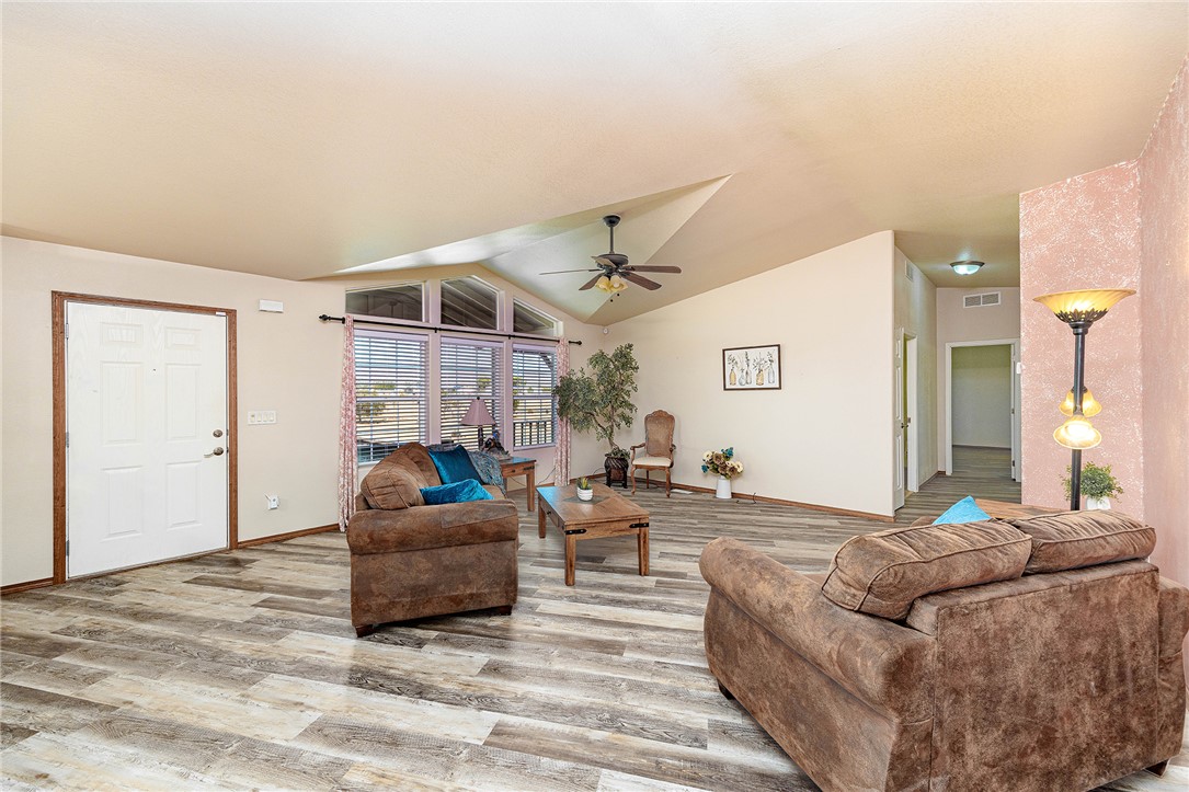 4206 Cordes Road Golden Valley, AZ 86413 - Photo 3 of 60 This living area features vaulted ceilings, wood-look flooring, and a ceiling fan