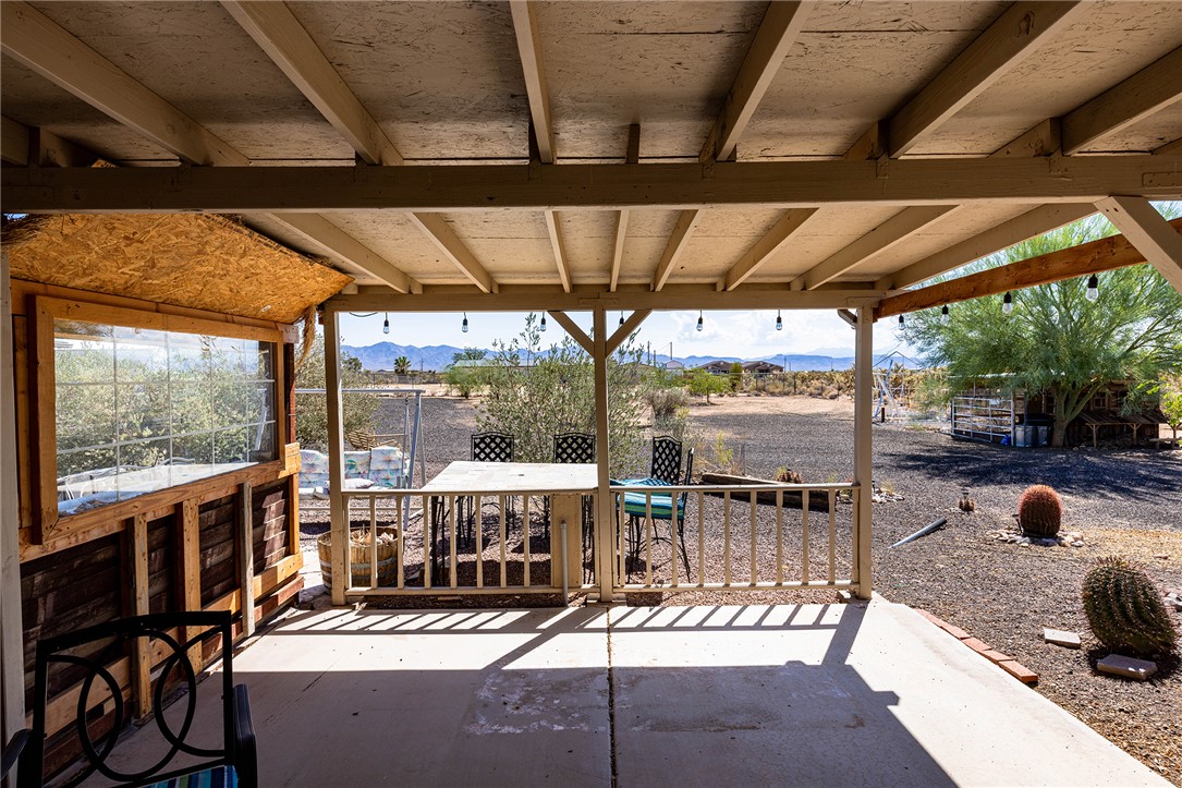4206 Cordes Road Golden Valley, AZ 86413 - Photo 31 of 60 The property features a covered patio with string lighting, offering views of the surrounding landscape and distant mountains