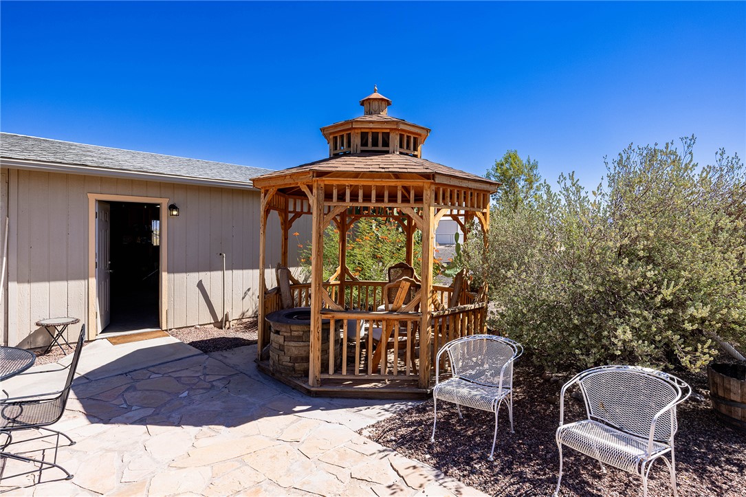 4206 Cordes Road Golden Valley, AZ 86413 - Photo 32 of 60 The property features a charming wooden gazebo with a multi-tiered roof, set on a flagstone patio