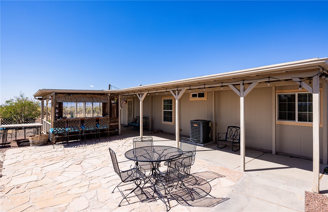 4206 Cordes Road Golden Valley, AZ 86413 - Photo 34 of 60 The property features an extensive outdoor area with a covered patio, a stone paved section, and a separate covered structure