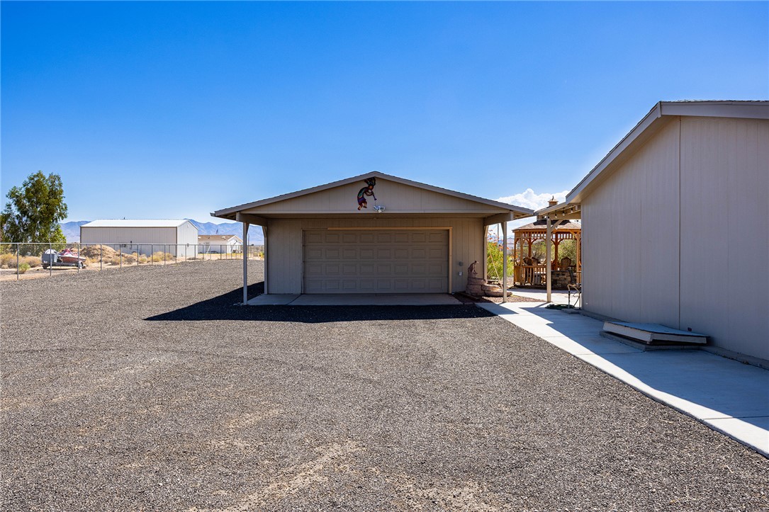 4206 Cordes Road Golden Valley, AZ 86413 - Photo 37 of 60 Detached garage with a roll-up door, situated on a large gravel lot