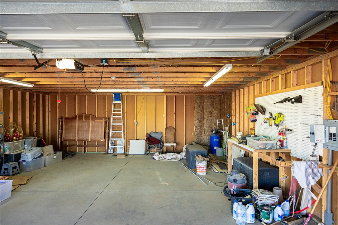 4206 Cordes Road Golden Valley, AZ 86413 - Photo 39 of 60 Spacious garage featuring exposed wooden beams, concrete flooring, fluorescent lighting, and a workbench