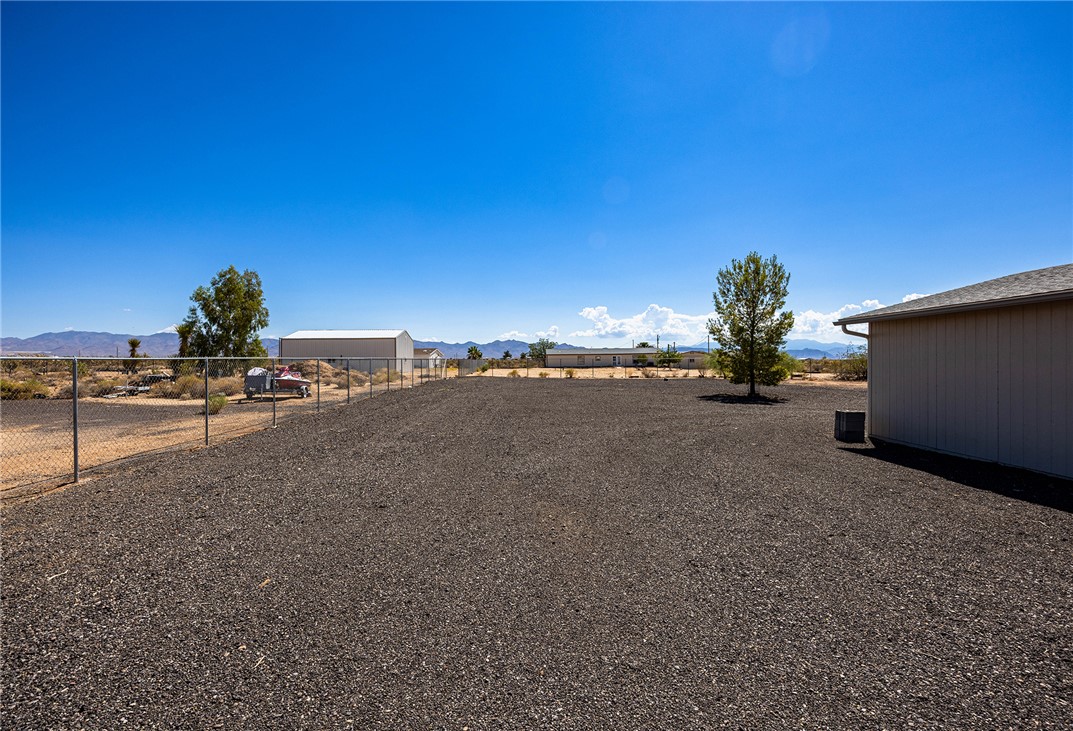 4206 Cordes Road Golden Valley, AZ 86413 - Photo 42 of 60 The property features an extensive gravel yard, a chain-link fence, and a single tree
