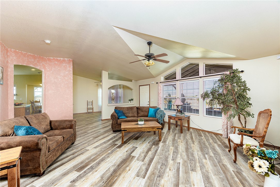 4206 Cordes Road Golden Valley, AZ 86413 - Photo 5 of 60 The living area features vaulted ceilings, wood-look flooring, and windows with horizontal blinds