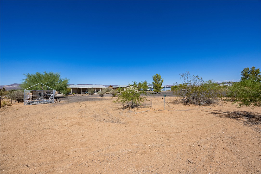 4206 Cordes Road Golden Valley, AZ 86413 - Photo 51 of 60 Expansive outdoor space with a clear blue sky, featuring a visible structure with a metal frame and scattered natural vegetation