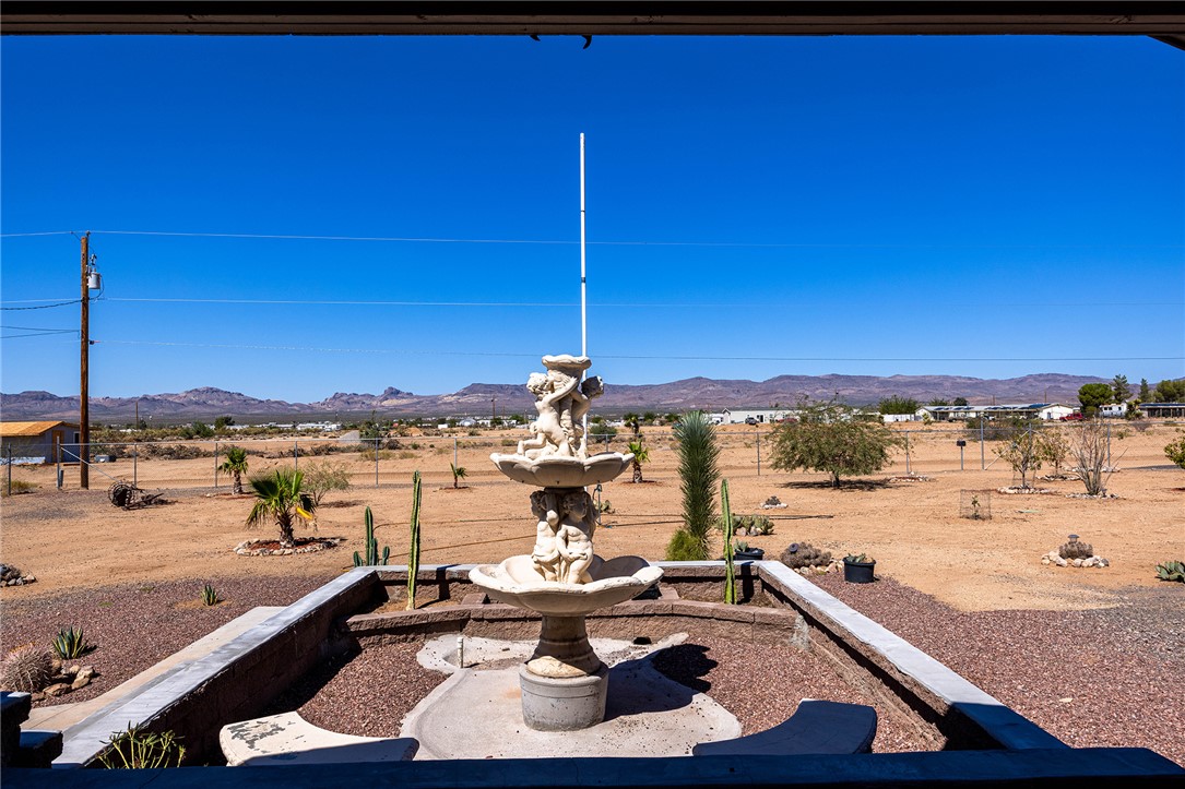 4206 Cordes Road Golden Valley, AZ 86413 - Photo 53 of 60 The property features a tiered fountain with sculptural details, set within a gravel-covered area