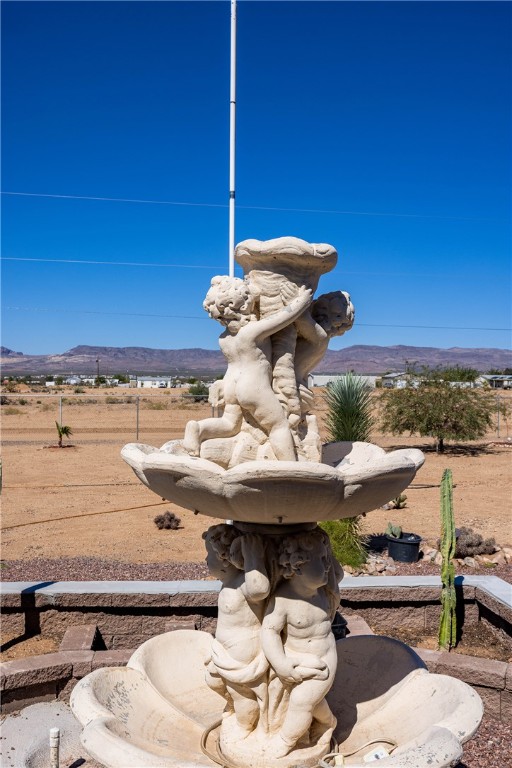 4206 Cordes Road Golden Valley, AZ 86413 - Photo 54 of 60 The property features a decorative outdoor fountain, set against a backdrop of a vast, uncultivated landscape with distant mountains