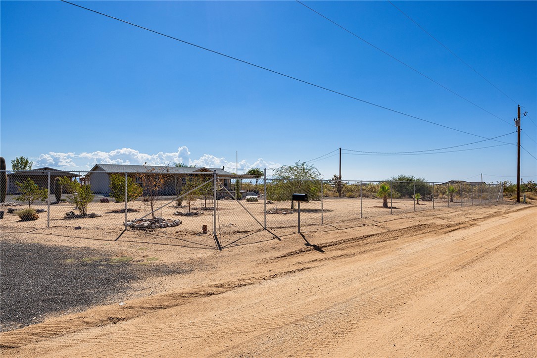 4206 Cordes Road Golden Valley, AZ 86413 - Photo 56 of 60 The property features a fenced yard with desert landscaping and a gravel driveway, offering open views
