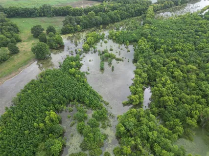 an aerial view of residential houses with outdoor space and trees