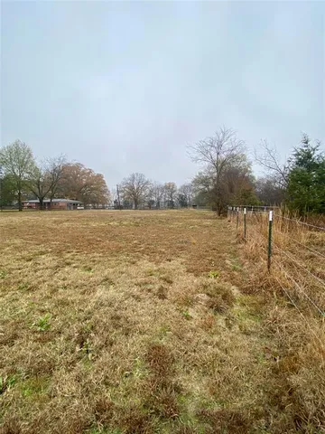 a view of a yard with wooden fence