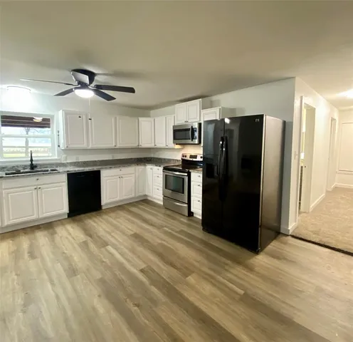 a kitchen with stainless steel appliances granite countertop a refrigerator and a sink