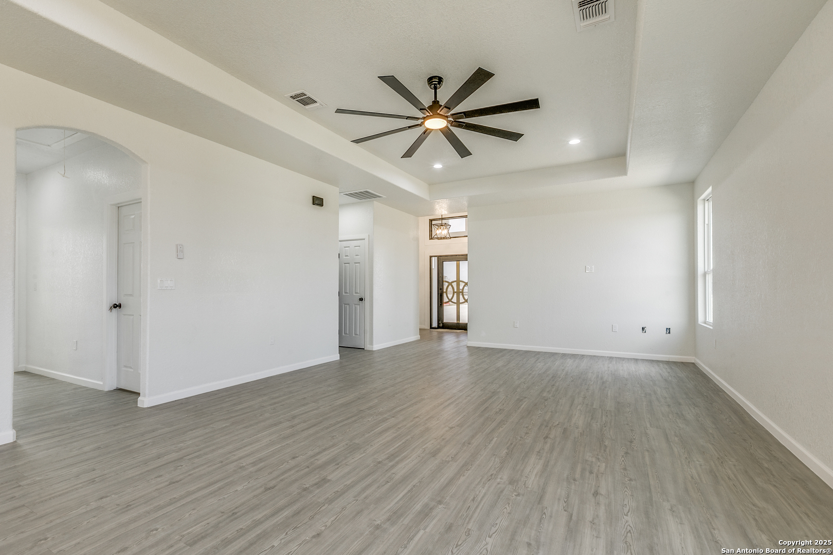 104 Flor Del Sol Road San Antonio, TX 78264 - Photo 18 of 29 an empty room with wooden floor a ceiling fan and windows