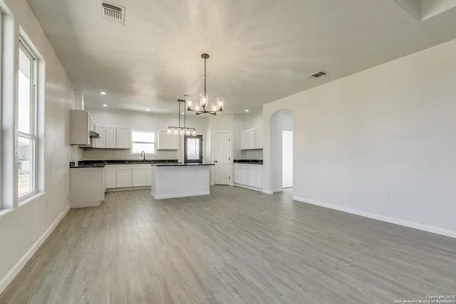 a view of a kitchen with a sink dishwasher a refrigerator and wooden floor