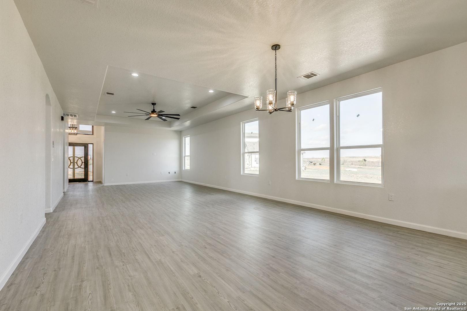 104 Flor Del Sol Road San Antonio, TX 78264 - Photo 20 of 29 an empty room with wooden floor chandelier and windows
