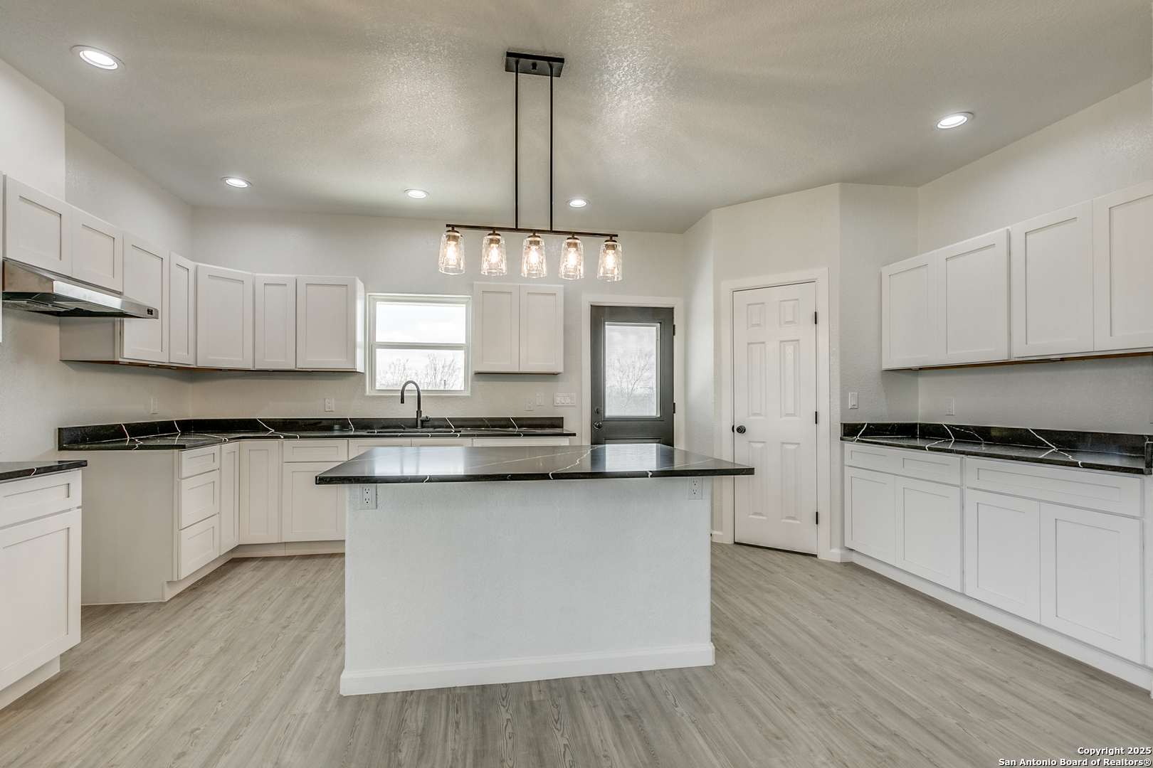 104 Flor Del Sol Road San Antonio, TX 78264 - Photo 21 of 29 a large kitchen with cabinets wooden floor and stainless steel appliances