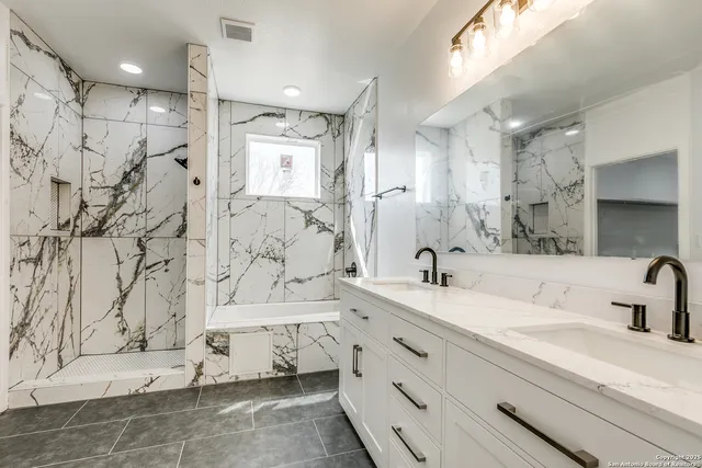 a bathroom with a double vanity sink mirror and shower
