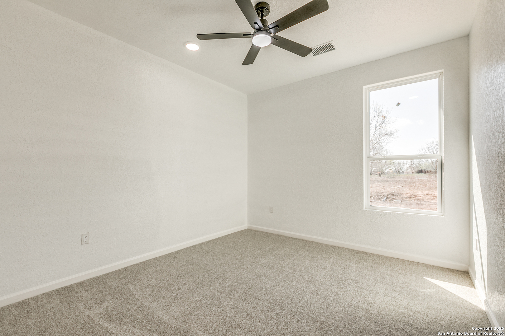 104 Flor Del Sol Road San Antonio, TX 78264 - Photo 29 of 29 an empty room with a window and a fan