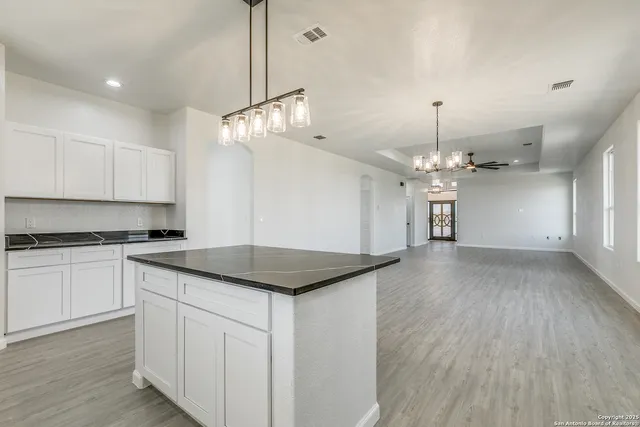 a kitchen with a refrigerator a sink and a stove top oven