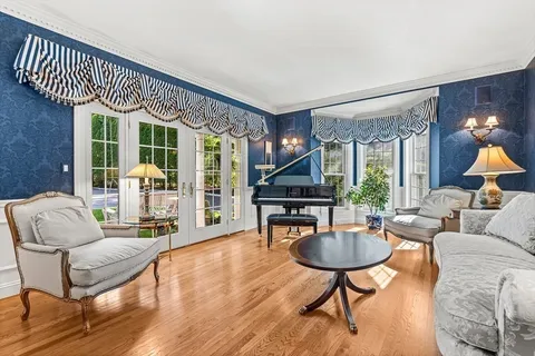 a living room with furniture a rug and a floor to ceiling window