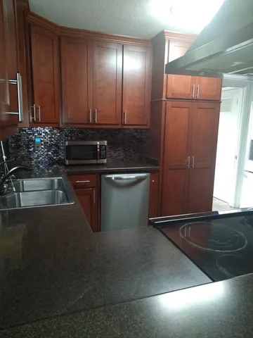 a kitchen with sink a refrigerator and cabinets
