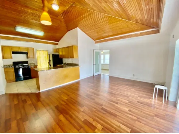 a view of a livingroom with wooden floor and furniture