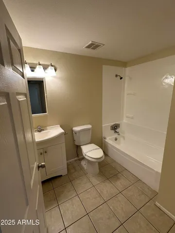 a white toilet sitting next to a bathroom sink and vanity