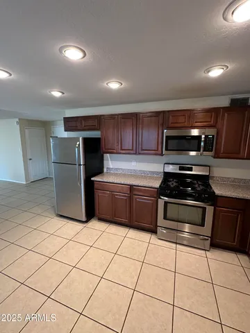 a kitchen with a stove a microwave and a refrigerator