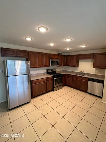 a kitchen with stainless steel appliances granite countertop a refrigerator sink and cabinets