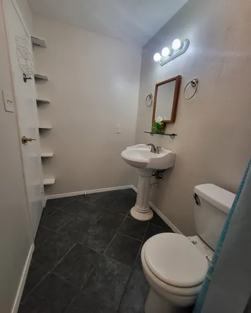 a white toilet sitting next to a bathroom sink