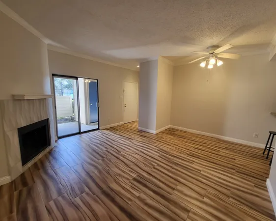 a view of empty room with wooden floor and fireplace
