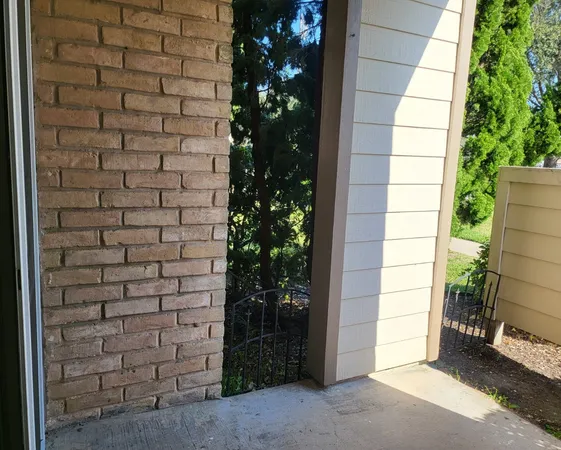 a brick building with a window and a tree