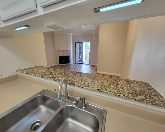 a view of kitchen sink and granite counter top