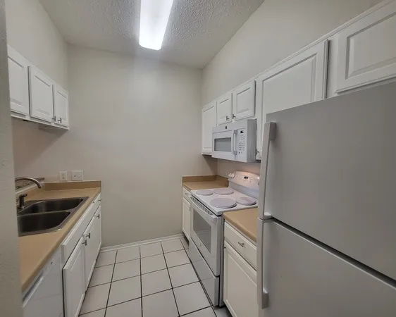 a kitchen with stainless steel appliances a stove a sink and a refrigerator