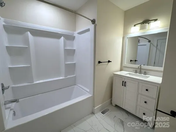a bathroom with a tub sink shower and mirror