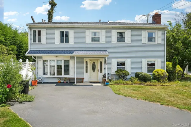 a front view of a house with a yard and outdoor seating