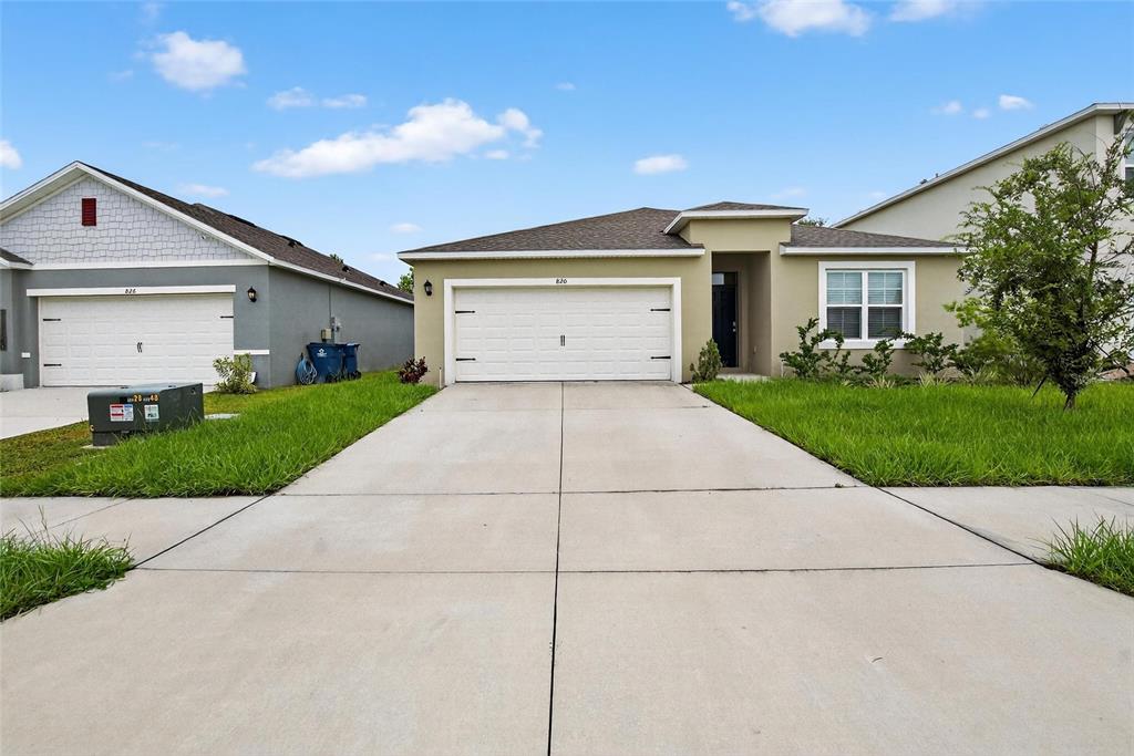 820 Sun Burst Road Winter Haven, FL 33880 - Photo 2 of 29 a front view of a house with a yard and garage