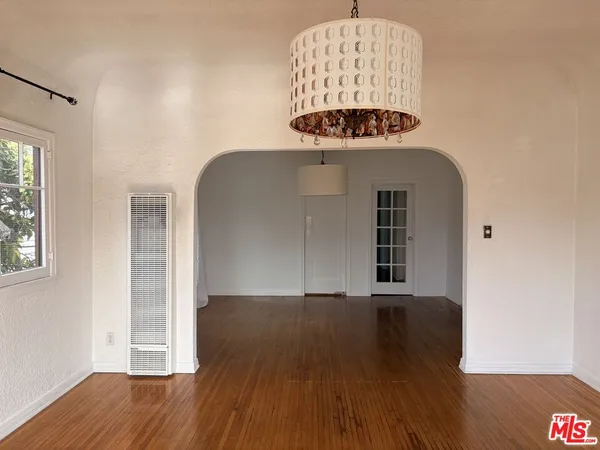 an empty room with wooden floor and a window