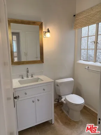 a bathroom with a toilet a sink and a window