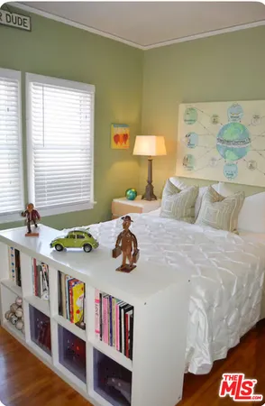 a bedroom with a bed and a book shelf