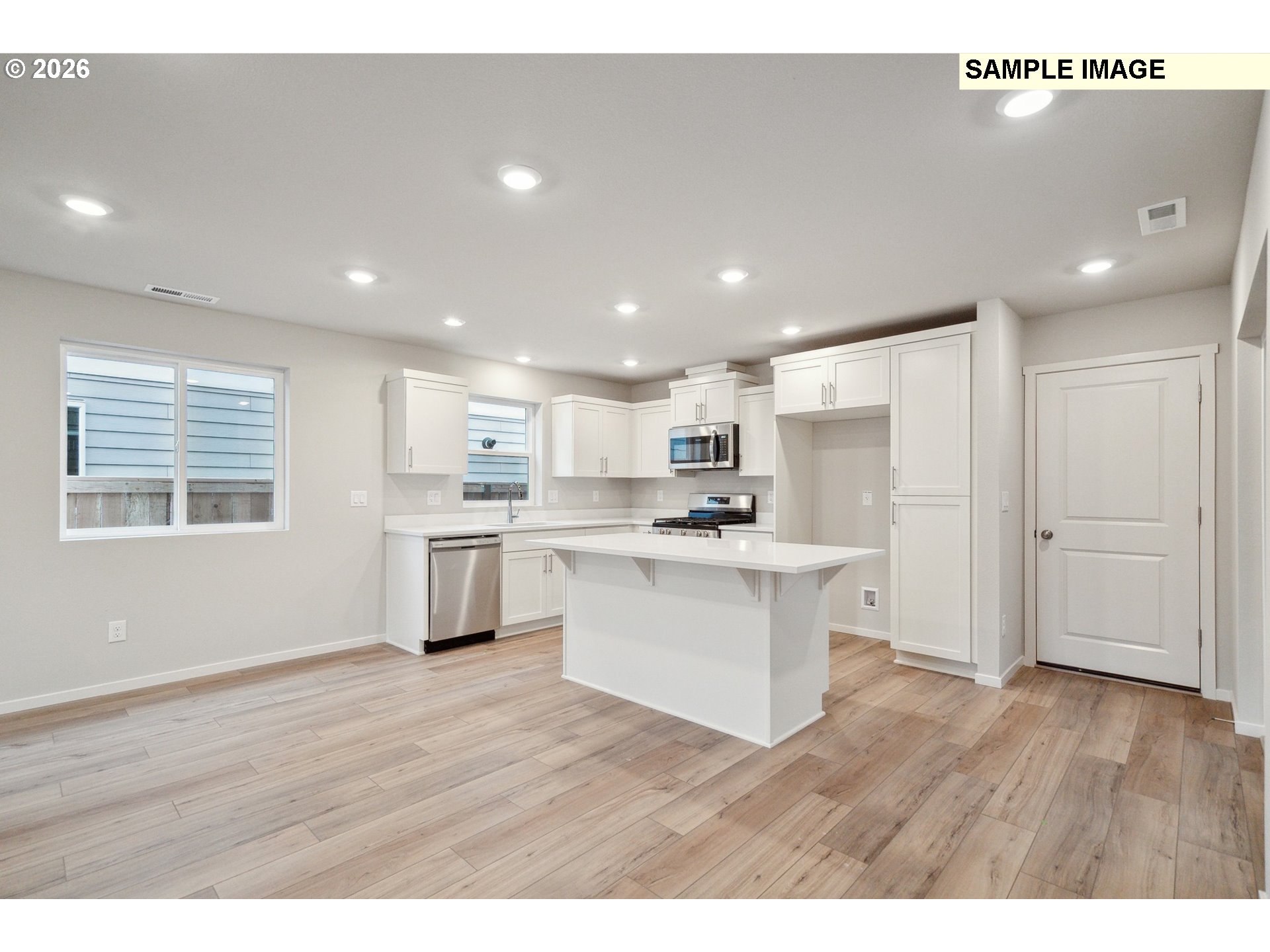 740 Merriott Lane Woodburn, OR 97071 - Photo 6 of 17 a kitchen with white cabinets and stainless steel appliances