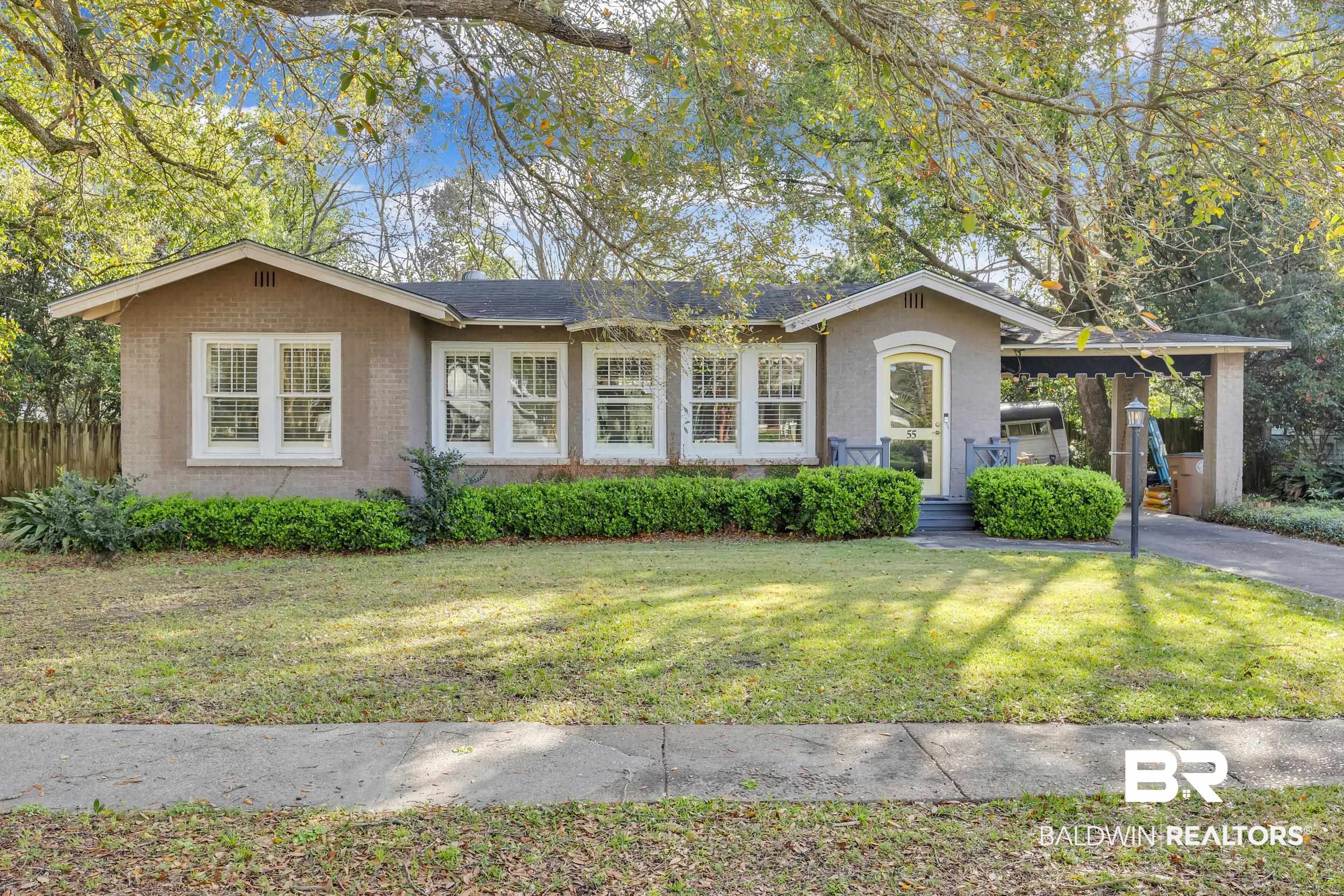 55 Mohawk Street Mobile, AL 36606 - Photo 1 of 28 View of front facade featuring brick siding, an attached carport, a front lawn, fence, and driveway